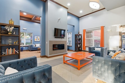 A living room with a blue couch and an orange coffee table.