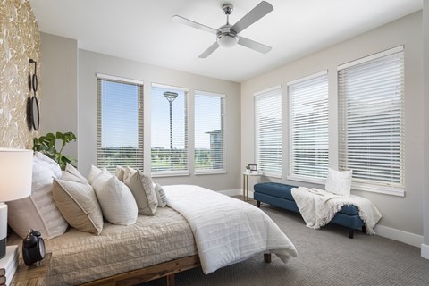A bedroom with a large bed and a blue bench.
