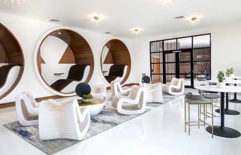 A modern living room with white furniture and a black and white geometric patterned wall.