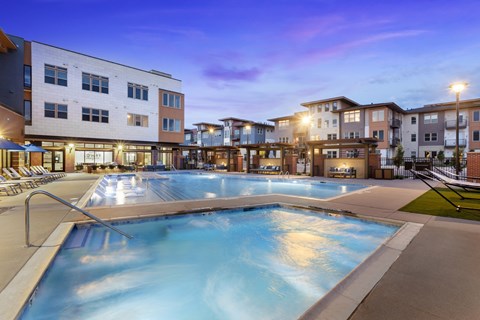 A large outdoor swimming pool surrounded by apartment buildings.