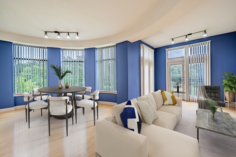 A living room with a white couch and a dining table.