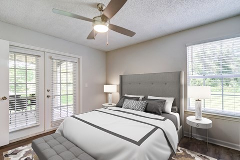 A bedroom with a large bed and a ceiling fan.
