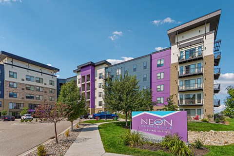 A purple and white building with a sign that says "NEON" in front of it.