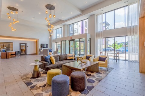 A large, open living room with a variety of seating options and a chandelier hanging from the ceiling.