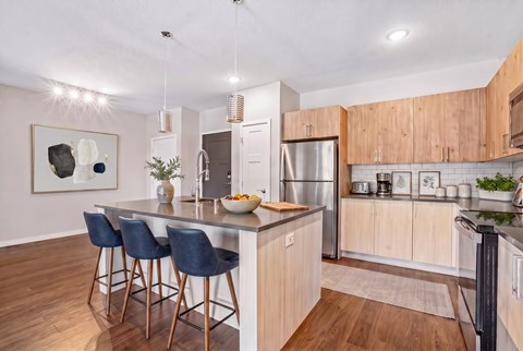 A modern kitchen with a bar area and a refrigerator.