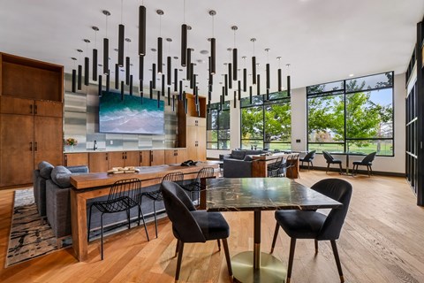A modern dining room with a long table and chairs.