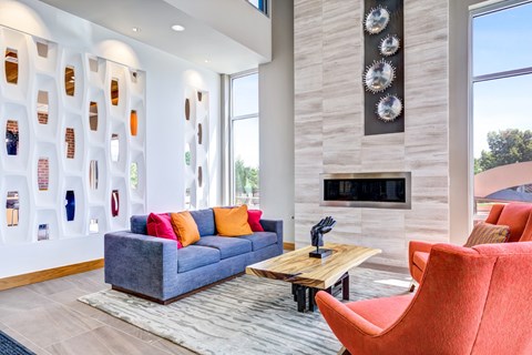 A living room with a grey couch and a red chair.