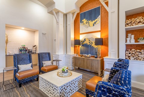 A living room with a white coffee table and blue chairs.