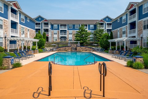 A swimming pool in front of apartment buildings.
