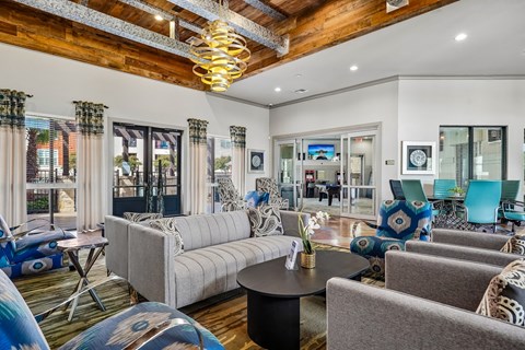 A living room with a grey sofa and a wooden ceiling.