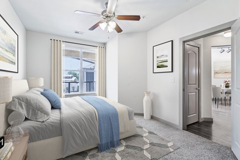 A bedroom with a large bed and a ceiling fan.