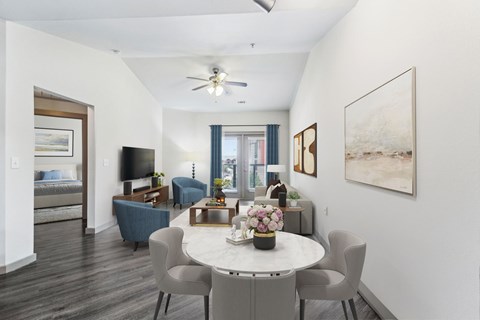 A dining room with a white table and grey chairs.