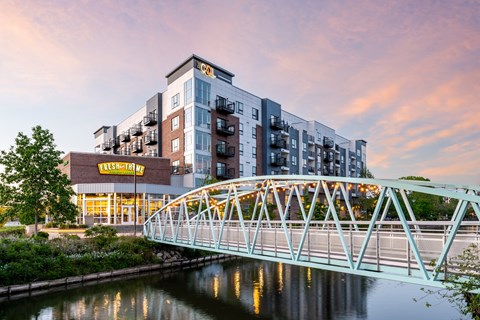 A bridge over a river with a building in the background.