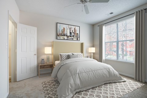 A bedroom with a large bed and a cityscape picture on the wall.