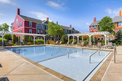 A large swimming pool in front of a red building.