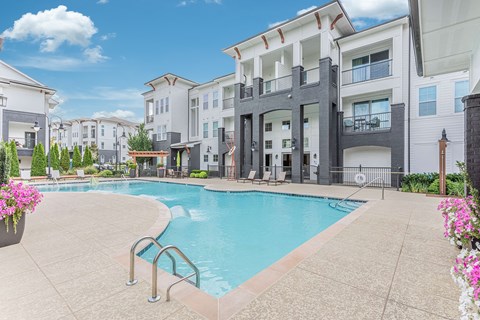 A swimming pool in a residential area with buildings in the background.