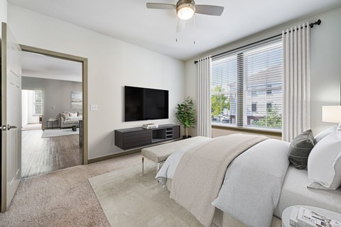 A bedroom with a large bed and a flat screen TV mounted on the wall.