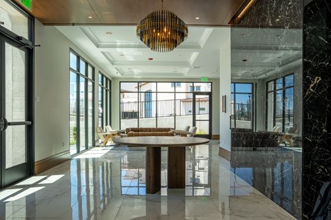 A modern dining room with a round table and a chandelier hanging from the ceiling.