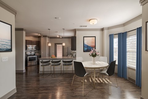 A modern dining room with a white table and chairs.