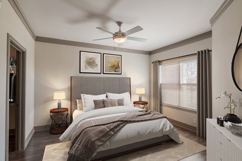 A bedroom with a large bed and a ceiling fan.