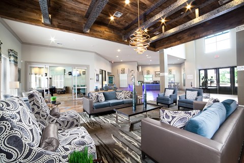 A living room with a patterned couch and a wooden ceiling.