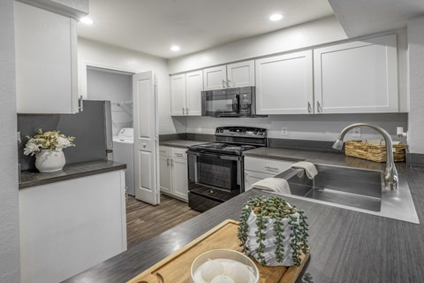 A modern kitchen with a wooden cutting board on the counter.
