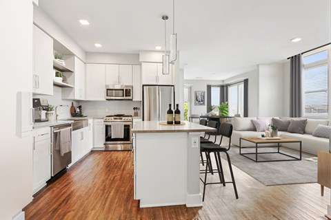 A modern kitchen with white cabinets and a wooden island.