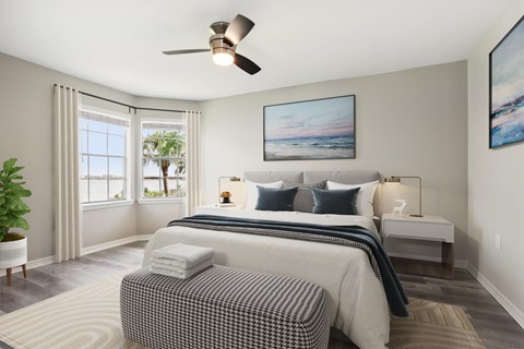 A bedroom with a large bed and a ceiling fan.