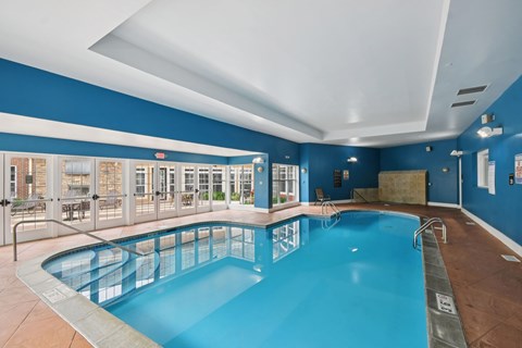 A large indoor swimming pool with a blue tiled wall.