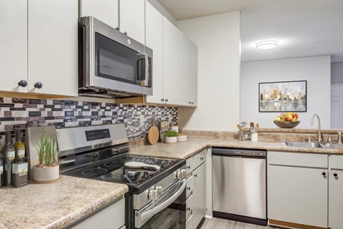 A kitchen with a stove top oven, microwave, and a sink.