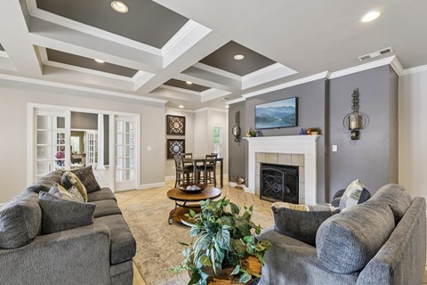 A living room with grey couches and a fireplace.