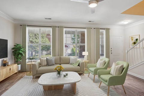 A living room with a sofa, two chairs, a coffee table, and a television.