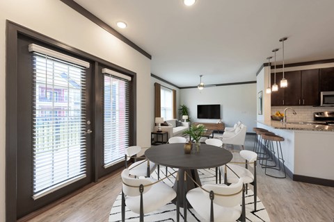 A modern dining room with a round table and white chairs.