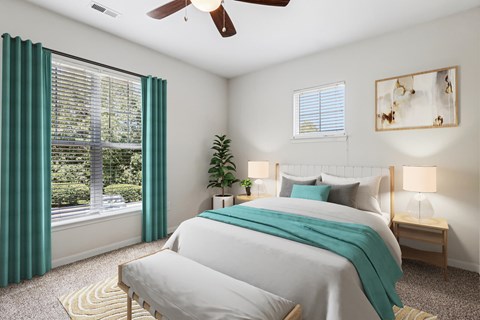 A bedroom with a large bed and a ceiling fan.