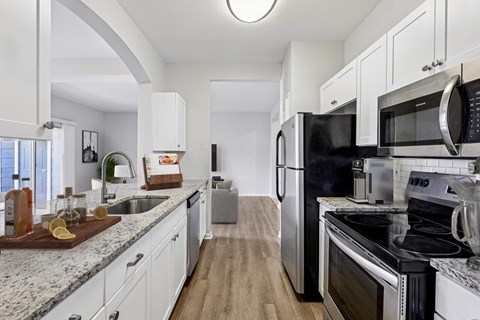 A kitchen with white cabinets and stainless steel appliances.