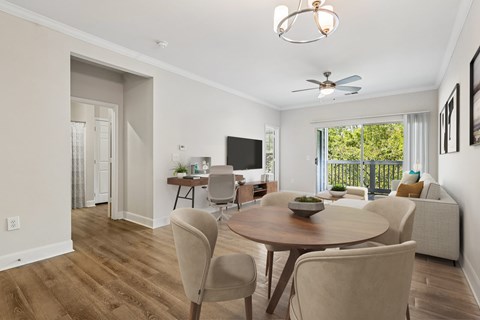 A well-lit dining room with a wooden table and chairs.