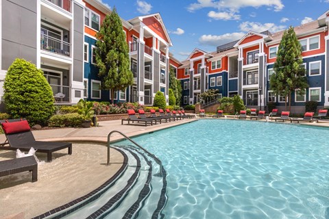 A large swimming pool in front of apartment buildings.