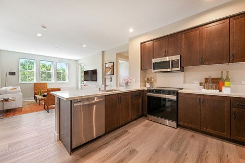 A modern kitchen with wooden cabinets and stainless steel appliances.