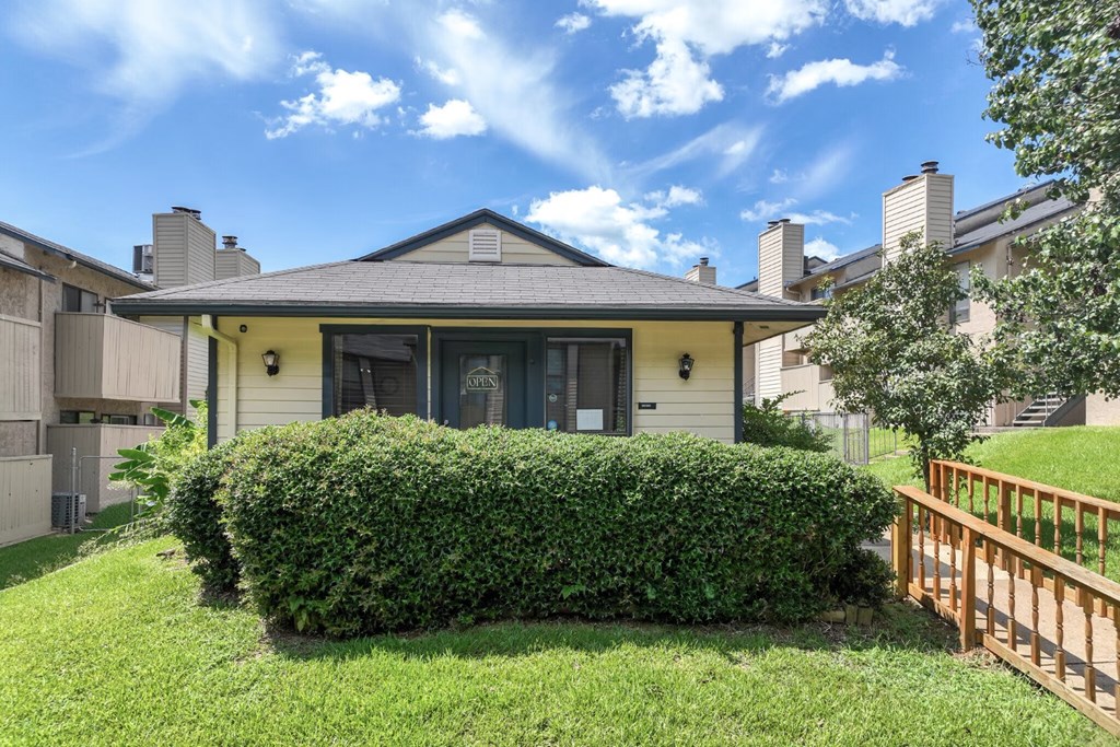 A house with a grey roof and a green lawn in front.