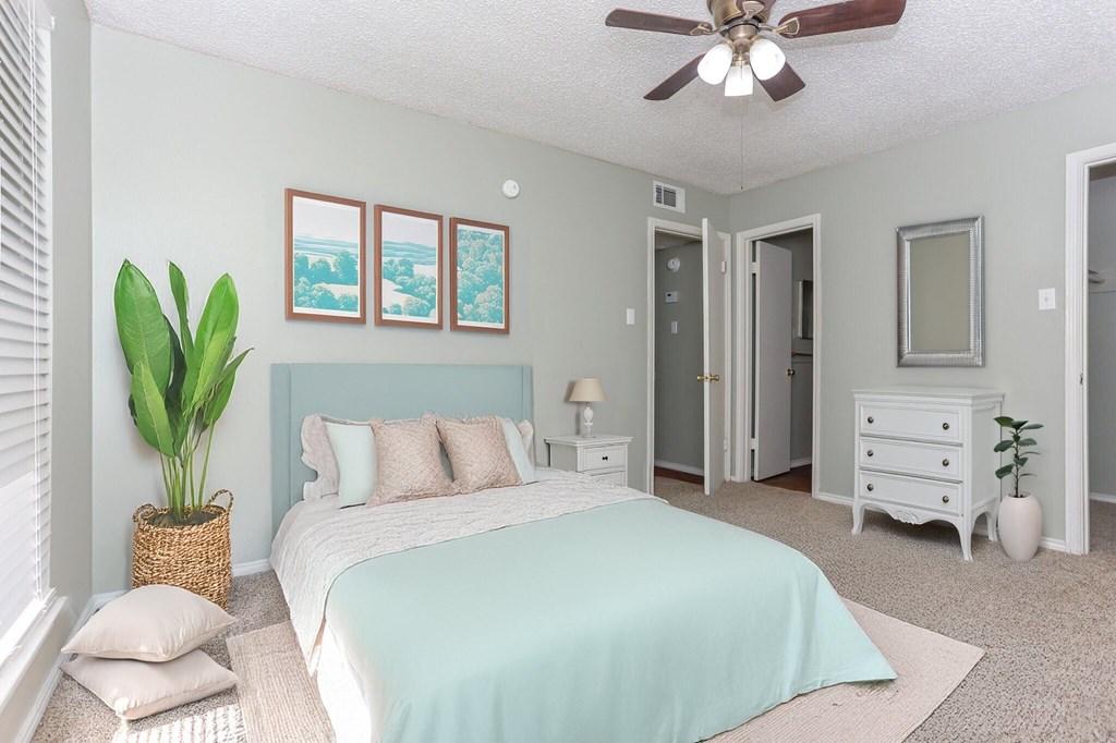 A bedroom with a bed, dresser, and mirror.