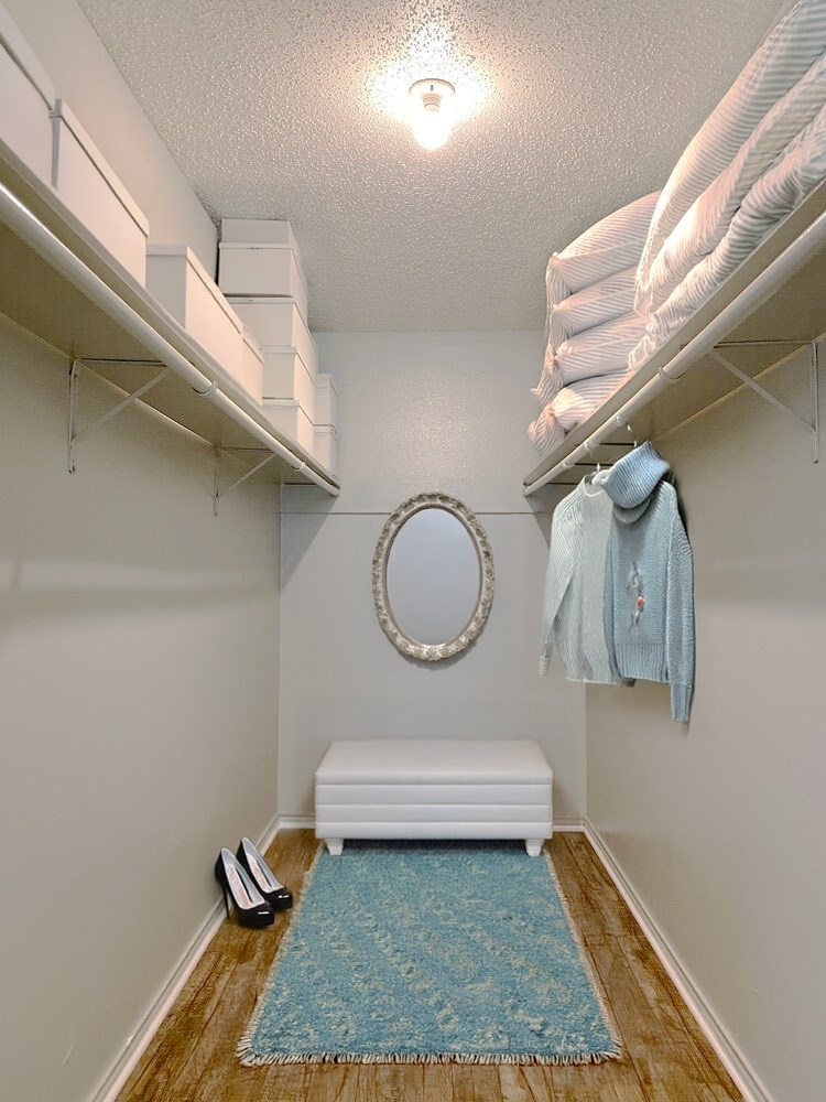 A small room with a round mirror and a white bench.