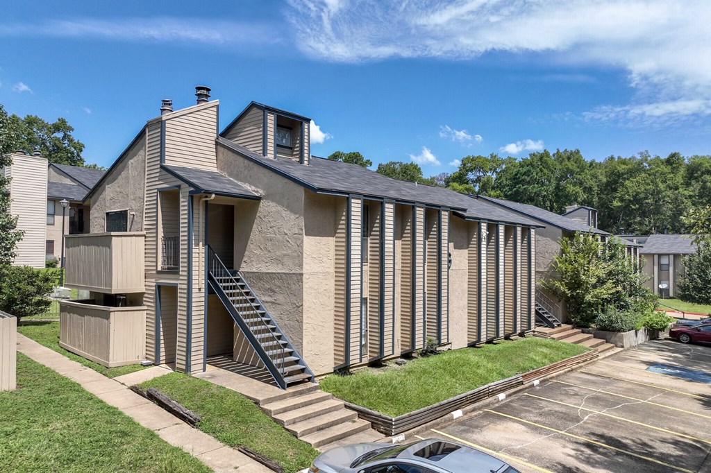 A modern building with a parking lot in front.
