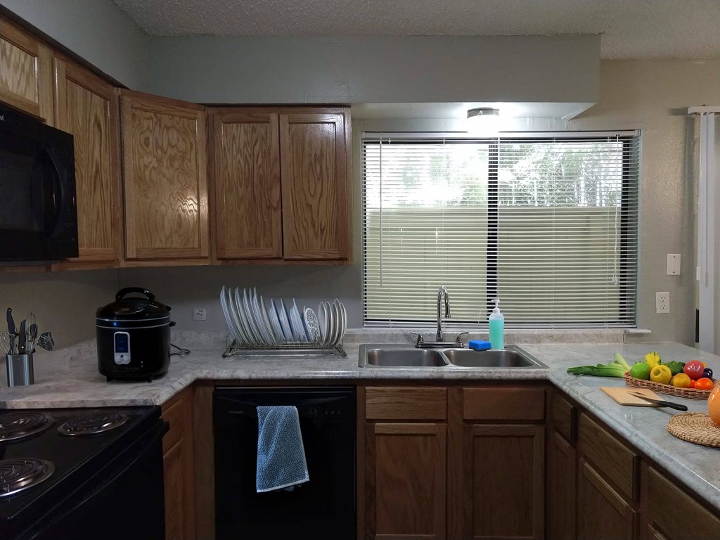 A kitchen with wooden cabinets and a black stove top oven.