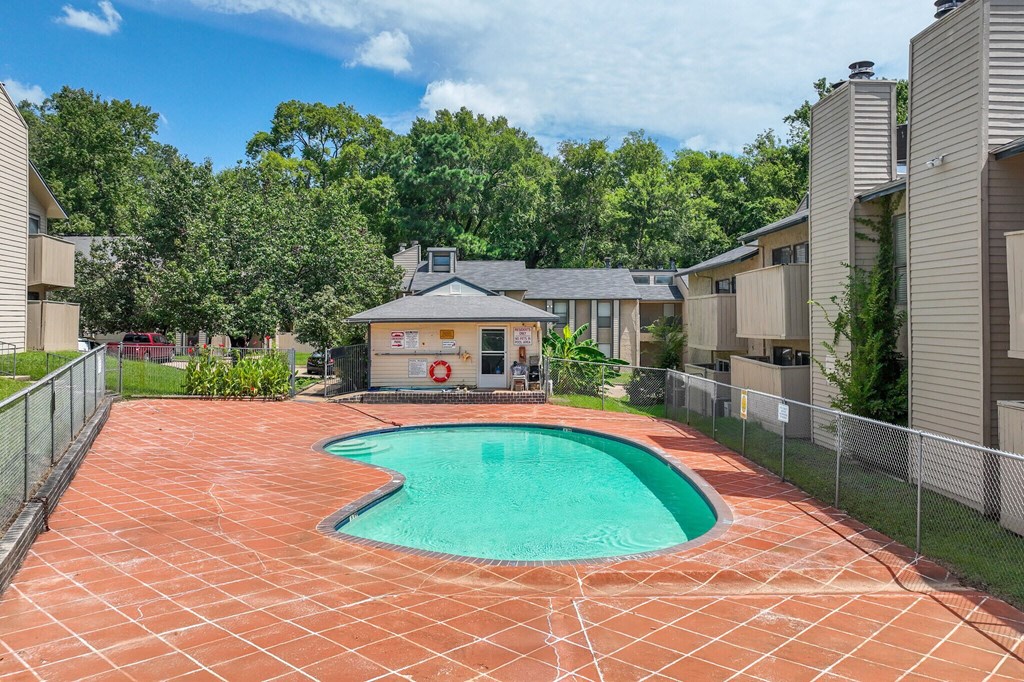 A small pool in a backyard surrounded by a fence.