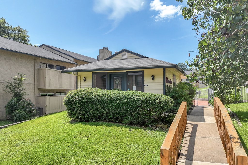 A house with a well-maintained lawn and a wooden fence.