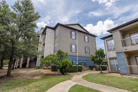 Apartment complex with a walkway in front.