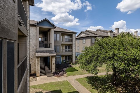 Apartment complex with a green lawn in front.