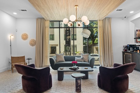 A living room with a brown chair and a table with a vase of flowers on it.