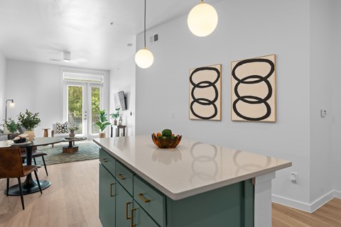 A kitchen with a white counter top and green cabinets.