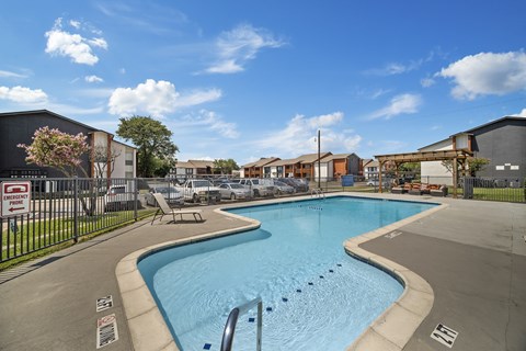 A swimming pool surrounded by a fence with a sign on it.